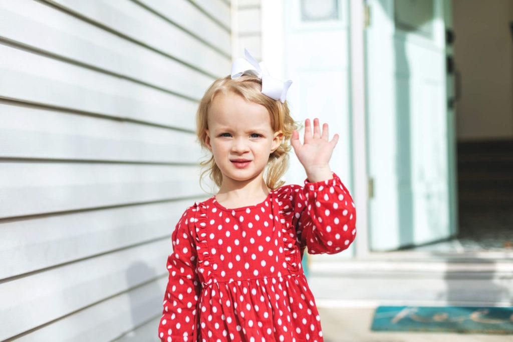 Little girl waving at daycare